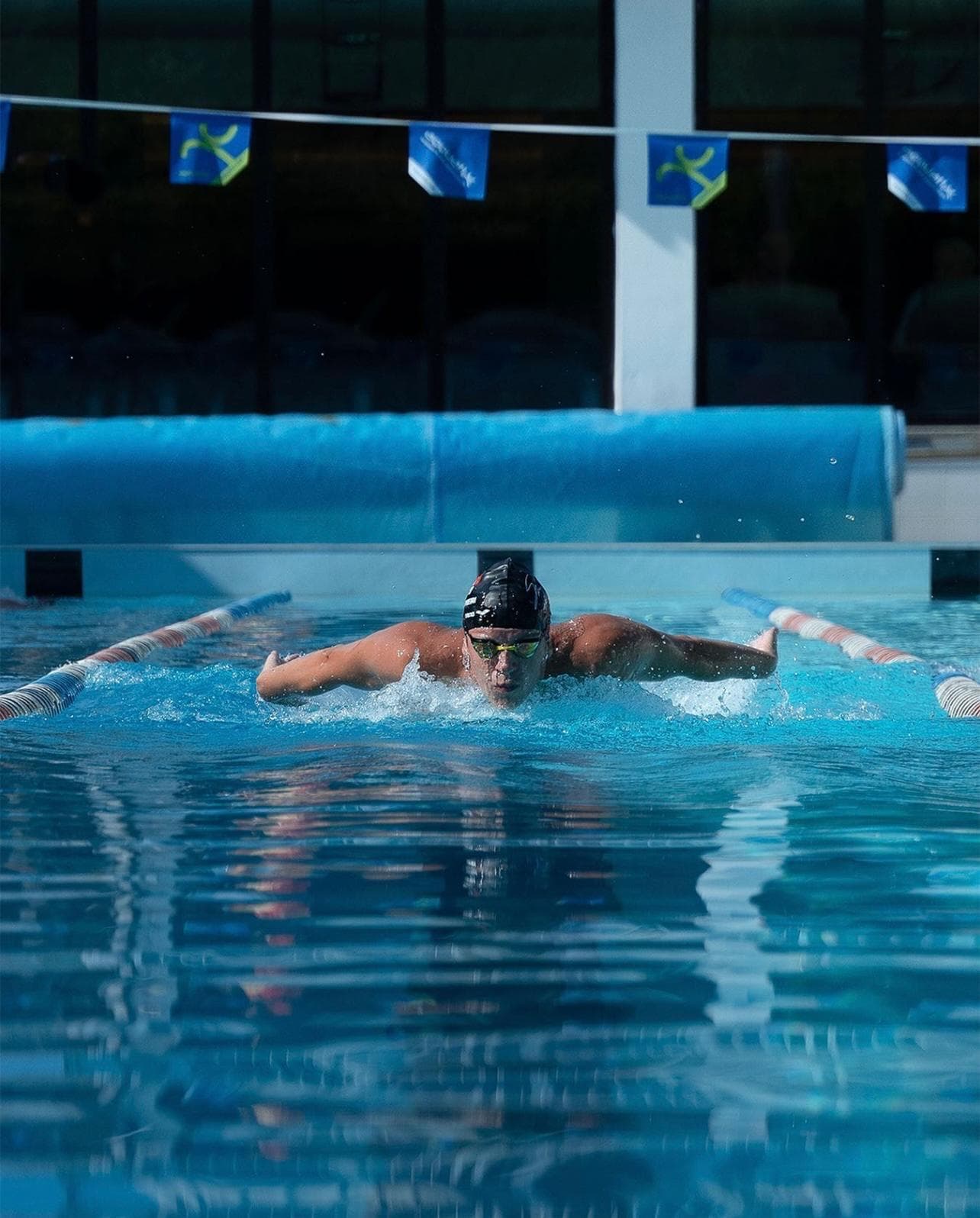 Nuotatore che procede a farfalla in una corsia della piscina